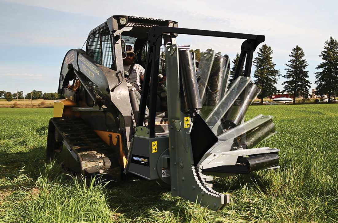 A skid steer with a Baumalight tree shear attached to it, designed for cutting down trees.